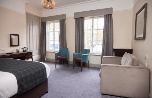 奥尔顿Swan Hotel by Greene King Inns的酒店客房配有一张床、一张沙发和椅子。