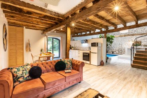马尔泰勒Les Hauts de Bagadou的一间带棕色沙发的客厅和一间厨房