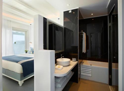 胡拉吉亚圣马可别墅酒店的一间卧室配有一张床和一个水槽和一个浴缸