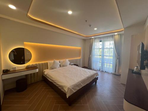 富国Tanya Phu Quoc Hotel的卧室配有白色的床和镜子