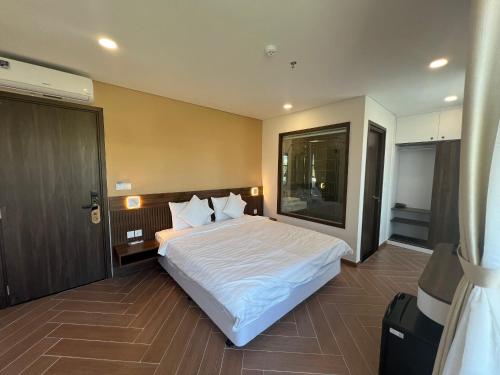 富国Tanya Phu Quoc Hotel的卧室配有一张白色的大床和一扇门