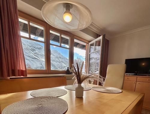 沃瑟姆阿尔伯格Hillside One - Ski-In Ski-Out Apartments am Arlberg的餐桌,享有雪覆盖的山脉美景