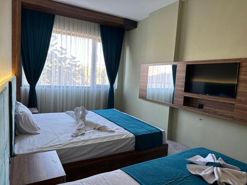 尚勒乌尔法Kançul Hotel Taştepeler的酒店客房设有两张床和一台平面电视。