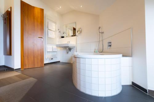 曼海姆达尔斯泰因酒店的浴室配有白色浴缸和水槽