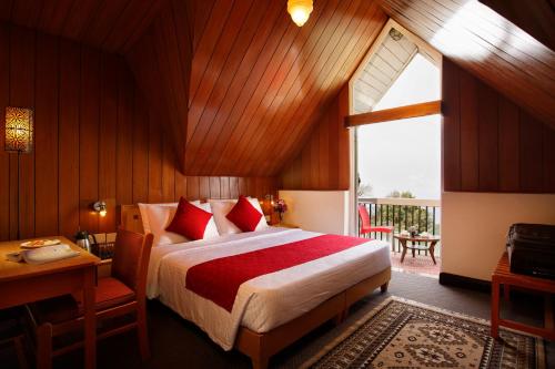 大吉岭Sterling Darjeeling的一间卧室配有一张床、一张书桌和一个窗户。