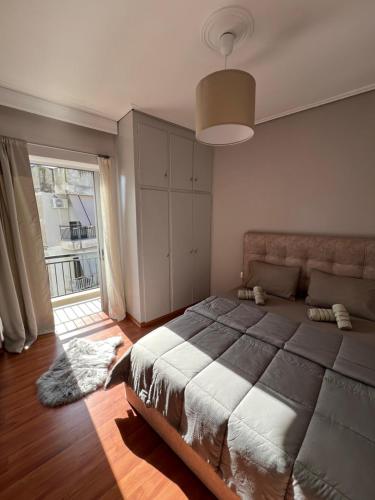 拉里萨TopCentral Apartment的一间卧室设有一张大床和一个大窗户