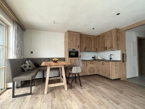 萨姆瑙恩Samnaun, ChaletdMot的厨房配有木制橱柜和木桌。