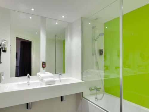 南特南特中心宜必思风格酒店的浴室配有水槽、淋浴和浴缸。