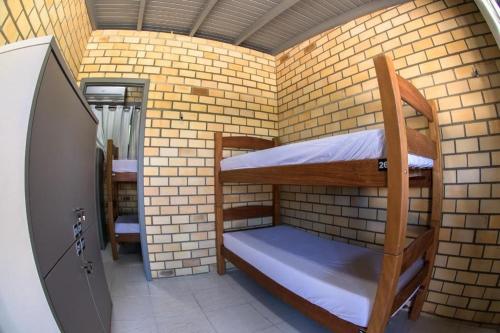 普腊亚罗萨Innbox - Praia do Rosa的一间小房间,在砖墙内配有双层床