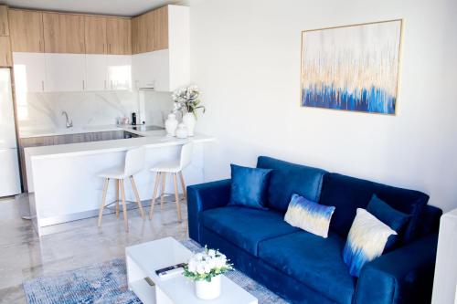 哈尔基斯Ermis Mini Suite # 3的一间带蓝色沙发的客厅和一间厨房