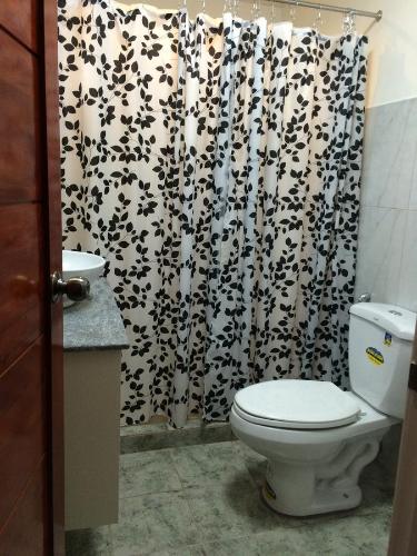黎牙实比Casa Roces的浴室设有卫生间和黑白淋浴帘。