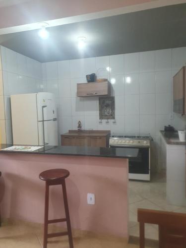 IpitangasCasa temporada da Nenê的厨房配有柜台、冰箱和凳子