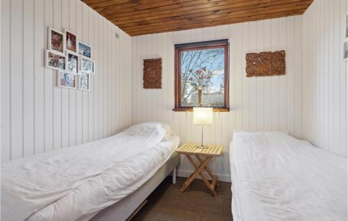 埃贝尔托夫特Amazing Home In Ebeltoft With Wifi的配有桌子和窗户的客房内的两张床