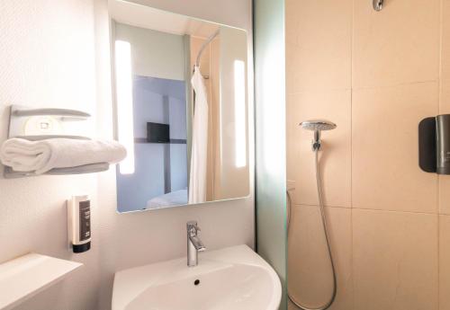 里摩日B&B HOTEL Limoges 1的一间带水槽和镜子的浴室