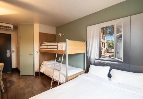 里摩日B&B HOTEL Limoges 1的一间卧室设有两张双层床和一扇窗户。