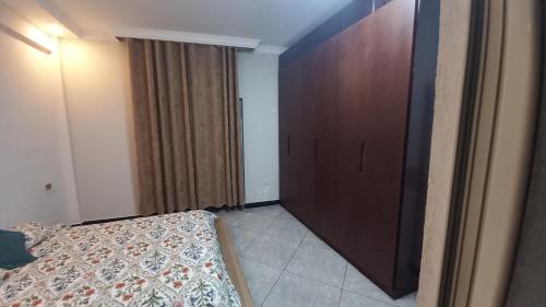 亚的斯亚贝巴G&19 Apartment的一间卧室配有一张床和一个木制衣柜