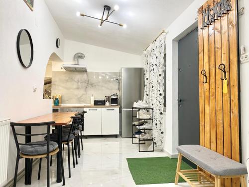 沃伊内亚萨Apartament - Voineasa的厨房以及带桌椅的用餐室。