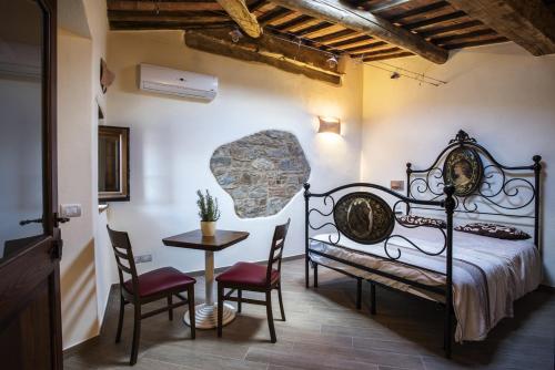 塞吉阿诺安蒂科博尔赛基诺住宿加早餐旅馆的卧室配有一张床和一张桌子及椅子
