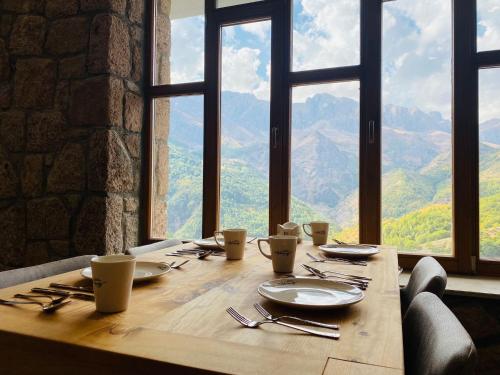 Askireg Hotel的一张带盘子和餐具的木桌,享有美景