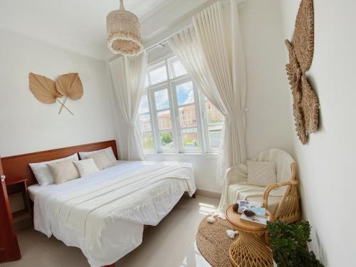 大叻Lantana Homestay的白色的卧室设有床和窗户