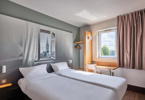 凯恩B&B HOTEL Caen Mémorial的酒店客房设有两张床和窗户。