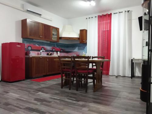 BrusimpianoIl Cavallino, sul lago Ceresio的厨房配有桌子和红色冰箱
