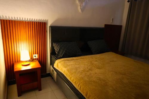 沙努尔Pondok Dete Guesthouse的一间卧室配有一张床和一张桌子上的台灯