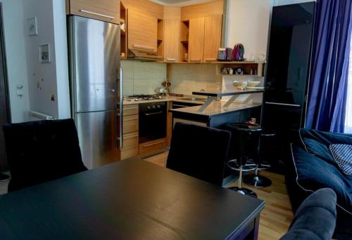 锡纳亚Apartament Stanca Piticului的一间带桌子的厨房和一间带冰箱的厨房