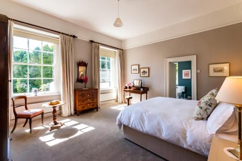 班敦Luxury country mansion in West Cork的一间卧室配有一张床、一张书桌和一个窗户。