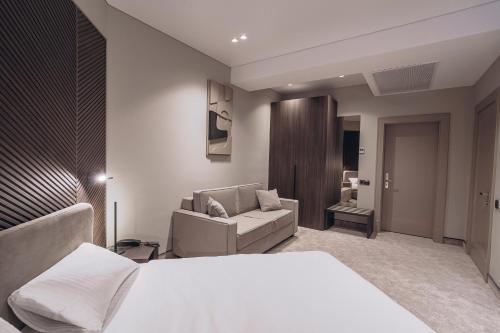 乌日霍罗德Park Hotel Bristol的卧室配有白色的床和沙发