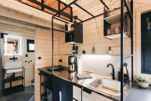 勒鲍Idyllisches Tiny House III mit Sauna的一个小房子里的厨房,配有水槽