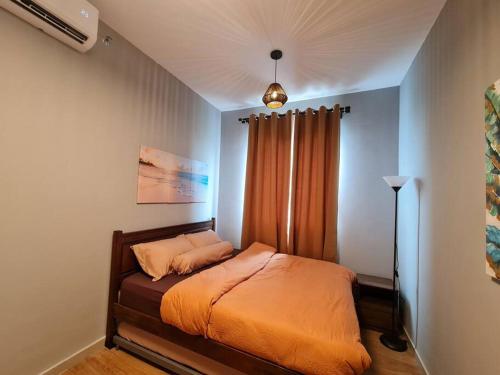 雪邦Luxury Tangerine Suites KLIA的一间卧室配有一张带橙色毯子的床