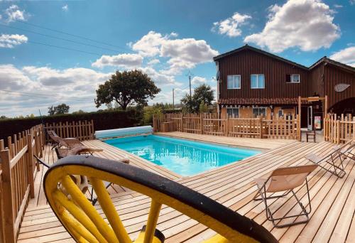 BouglonCamping Syl-Vallée Western Village的一个带游泳池和房子的木甲板