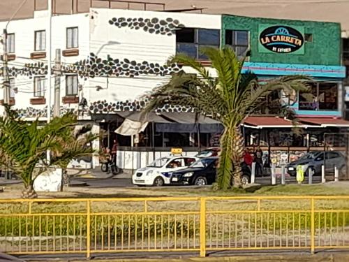 伊基克Hotel La Carreta Playa Brava的一条在大楼前停放汽车的街道