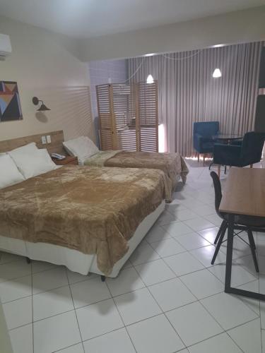 巴西利亚GARVEY PARK HOTEL的酒店客房设有两张床和一张桌子。
