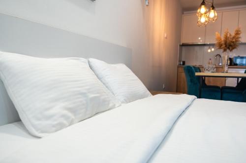 诺维萨德Daisy resort的白色的床和白色枕头顶部
