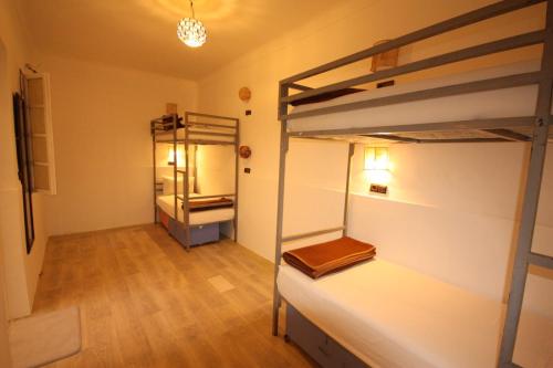 马拉喀什El Boussouni Hostel的客房设有两张双层床和衣柜。