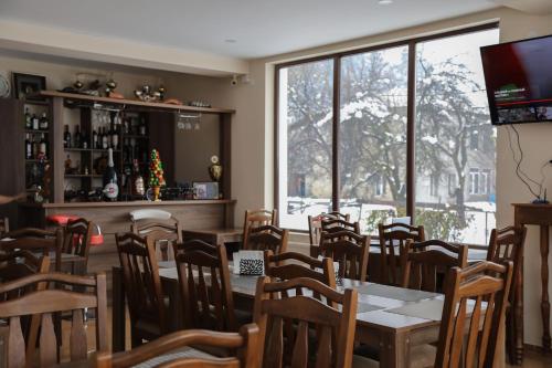 梅斯蒂亚Hotel Ramaz Paliani的一间带桌椅和窗户的用餐室