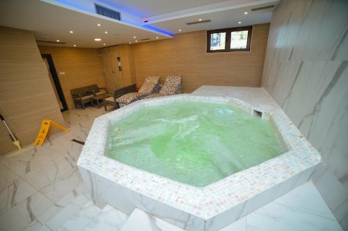 兹拉蒂博尔Zlatibor Breza Apartment and Spa的客厅设有大型按摩浴缸