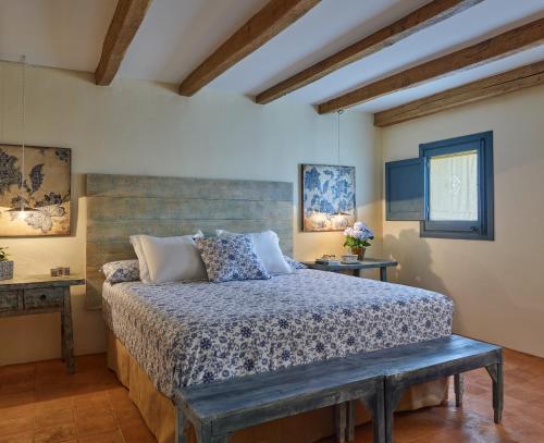 赫罗纳Els Masos de Caula的一间卧室配有一张床和长凳