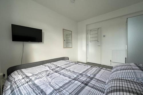 伦敦Stunning apartment in Dulwich的一间卧室配有一张床和一台平面电视