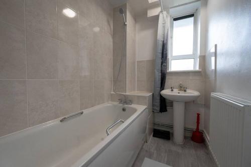 伦敦Stunning apartment in Dulwich的白色的浴室设有浴缸和水槽。