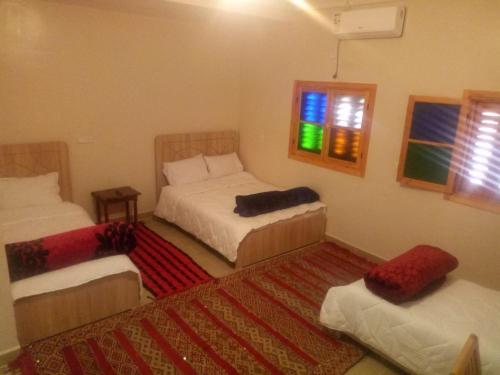 米德勒特Gite Vanadenite的一间卧室设有两张床、一个窗户和一个地毯。