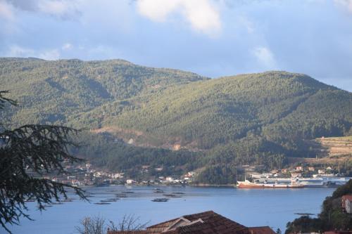 雷东德拉Casa en Chapela, al lado de Vigo y con vistas a la Ría的一大片水体,背景是群山