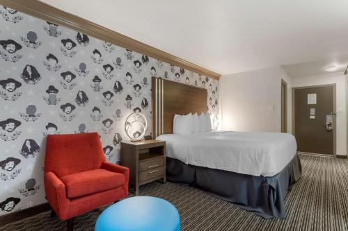 奥斯汀Aiden by Best Western Austin City Hotel的酒店客房,配有一张床和一张红色椅子