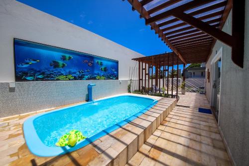 马拉戈日O Azul de Maragogi - Pousada Premium的一座室内游泳池,墙上设有水族馆