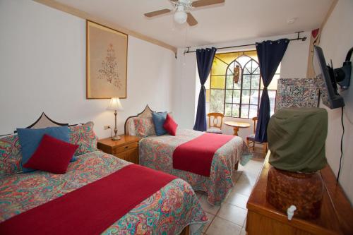 阿吉吉克卡萨布兰卡酒店的一间卧室设有两张床、一台电视和一扇窗户。