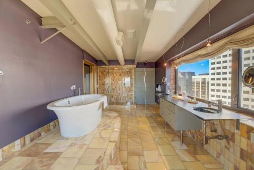 克利夫兰1600 KCM Penthouse Apartment的带浴缸和大窗户的大浴室