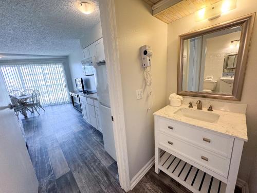 威尔伍德克拉斯特水族海滩酒店 的一间带水槽和镜子的浴室以及一间厨房