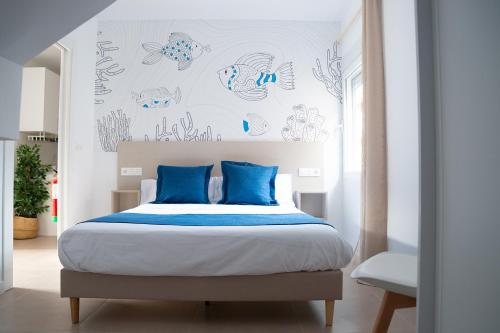 马萨龙港Apartamentos Barlovento的一间卧室配有一张带蓝色枕头的大床